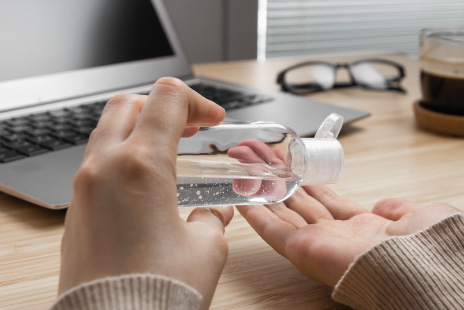 Using hand sanitiser by desk