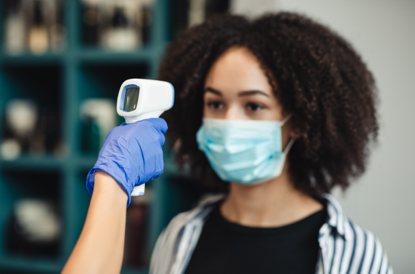 Measuring woman's temperature with non-contact thermometer