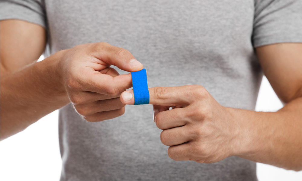Blue plaster on man's finger