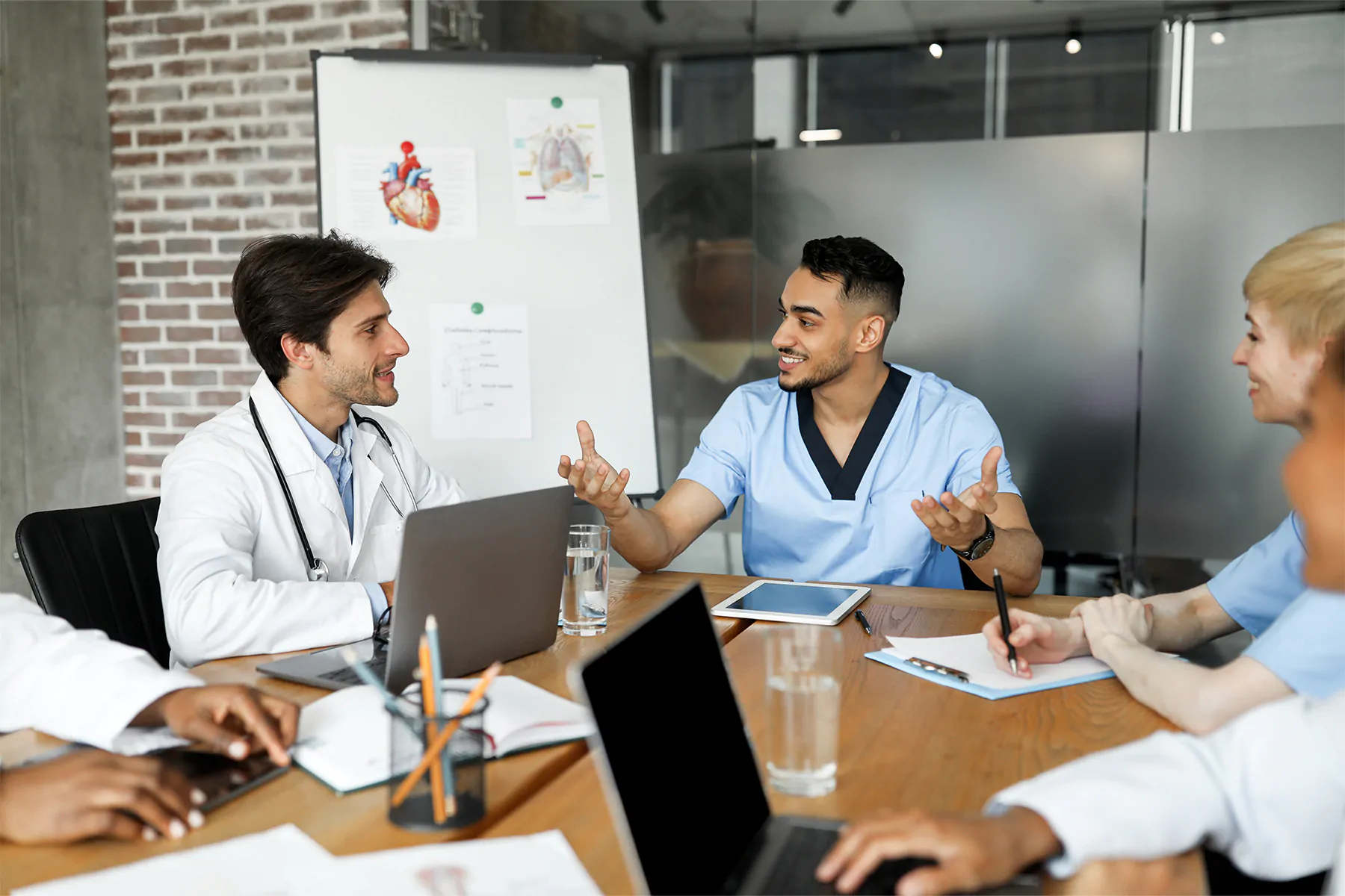 Cheerful doctors multiracial team having briefing, discussing cases Cheerful doctors multiracial team having briefing, discussing cases