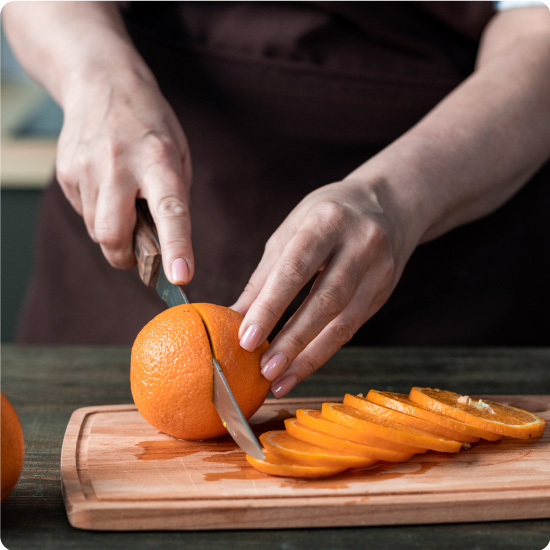 Chef cutting an orange into slices