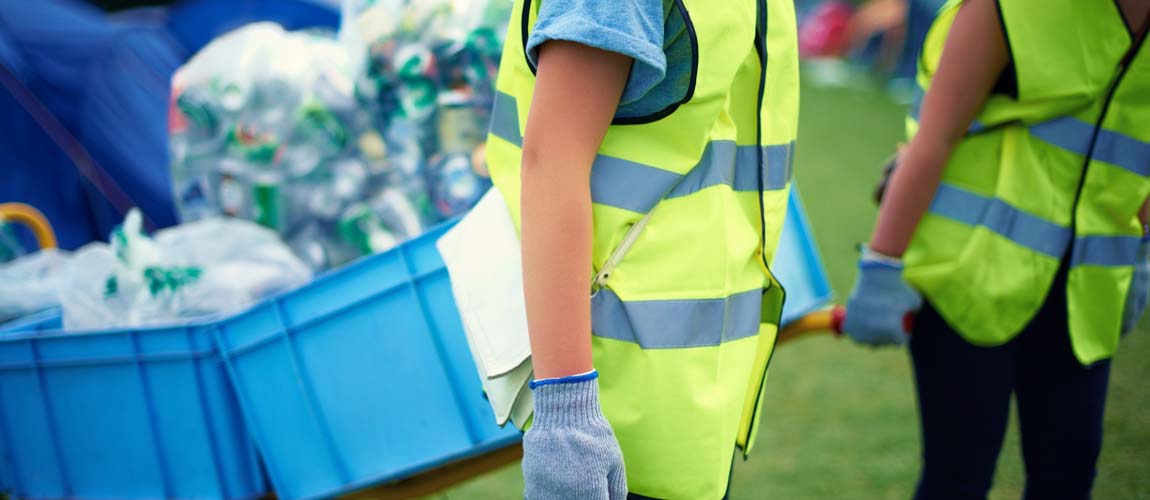 Close Up Of Female Volunteers Picking Up Litter In The Countryside