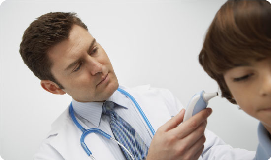 Male doctor's hand checking little boy with digital thermometer