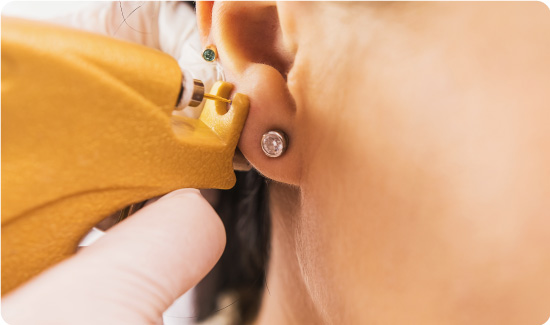 Woman getting an ear piercing
