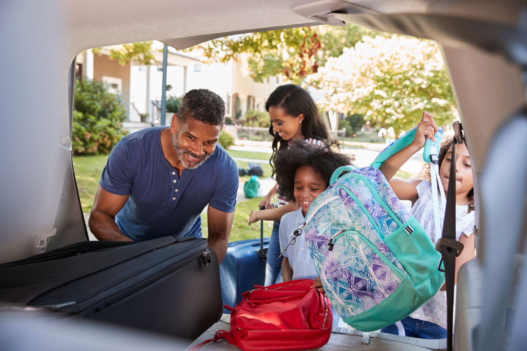 Family leaving house to their car for a holiday