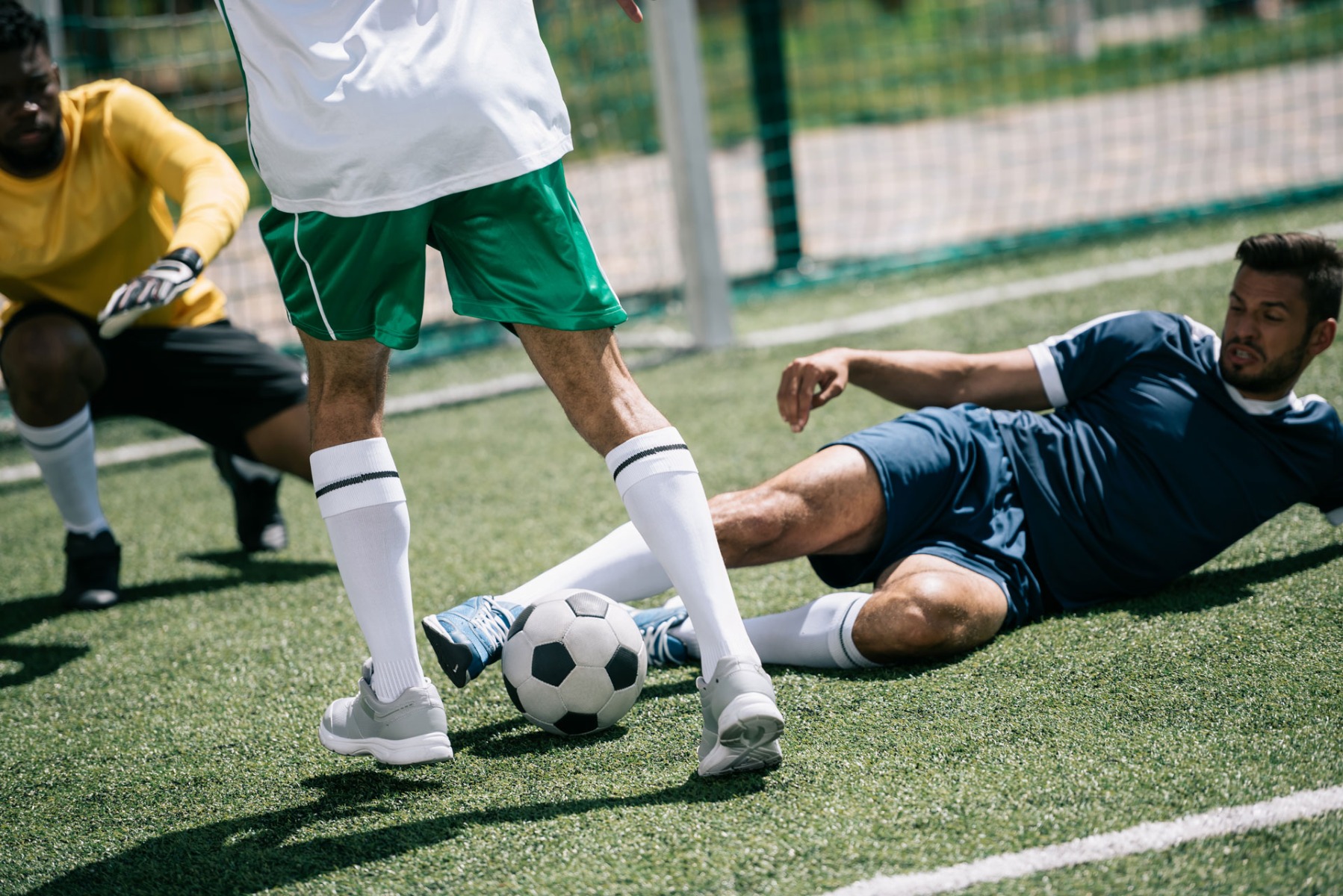 footballer tackling on football pitch