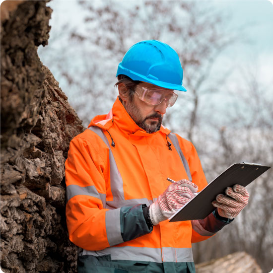 Forestry technician writing notes on clipboard notepad paper in forest