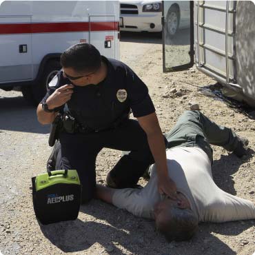 Police Officer Attending to a collaped man with a Zoll AED Plus