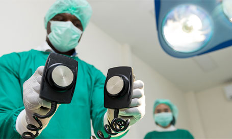 A doctor using a defibrillator