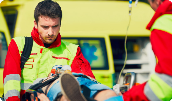 Paramedics moving someone on a stretcher into an ambulance