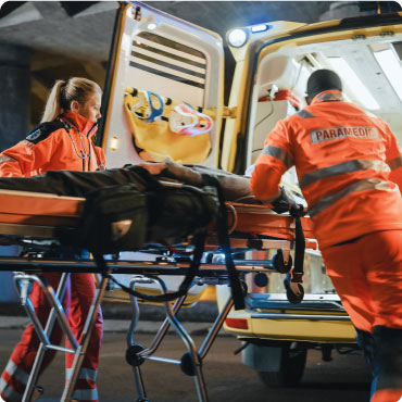 Paramedics transferring patient onto an ambulance on a stretcher