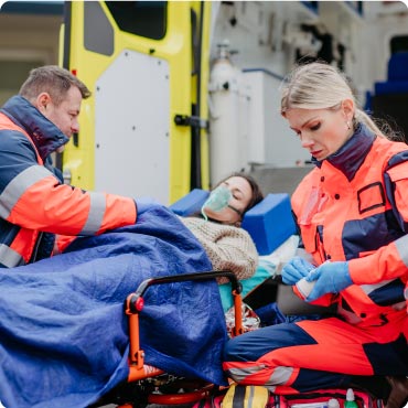 Paramedics transferring patient onto an ambulance on a stretcher