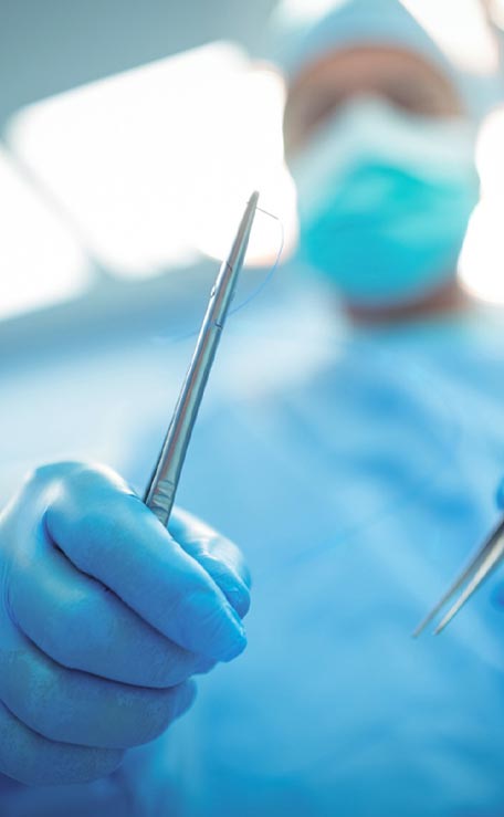 Surgeon holding surgical tools in operation theater
