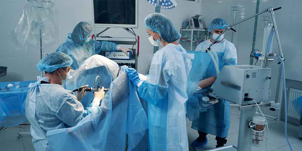 Four surgery specialist in operating theater treating patient