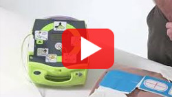 Thumbnail showing the ZOLL AED Plus device with electrode pads displayed, part of a basic training video on AED usage.