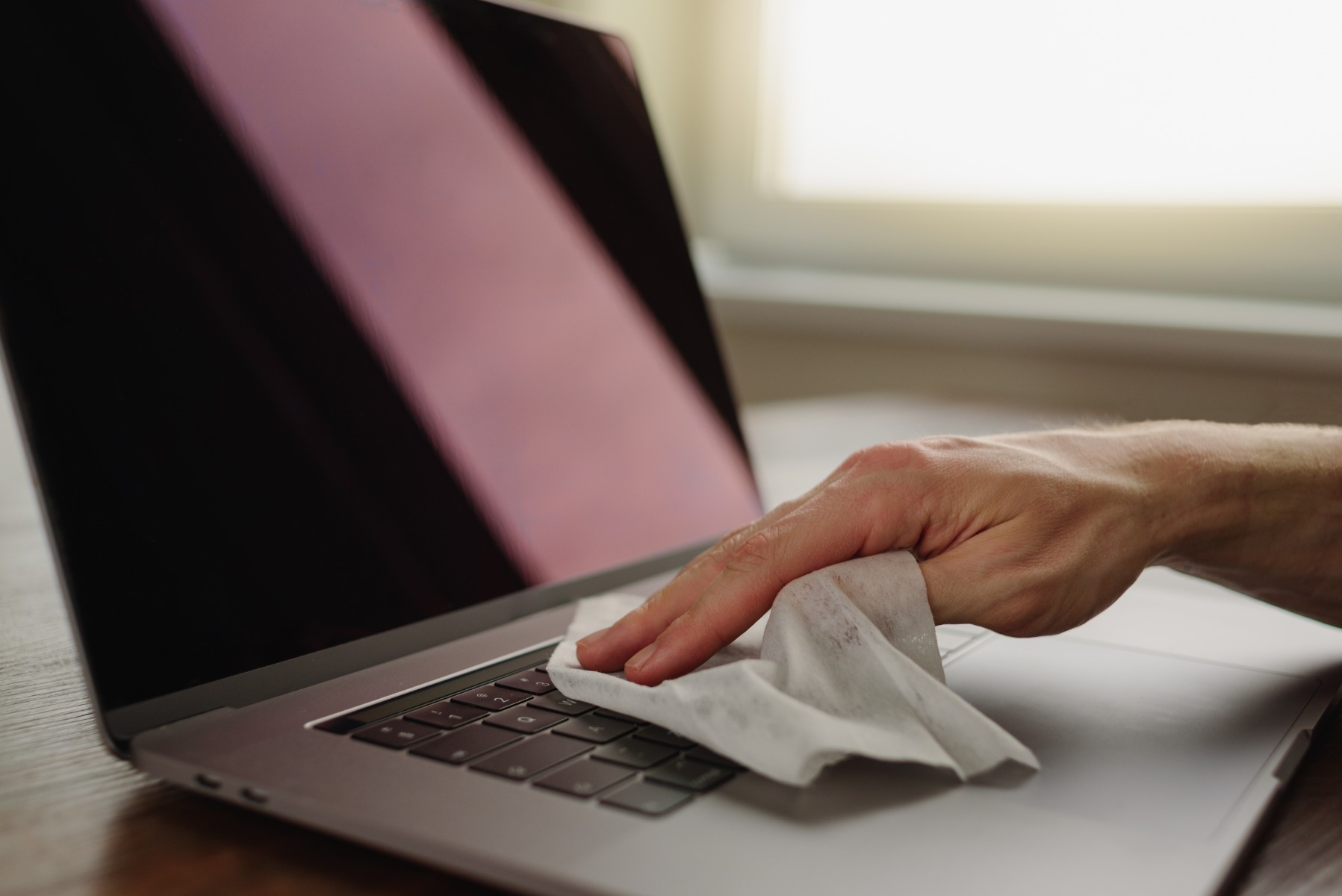 wiping computer and surface with alcohol wipe