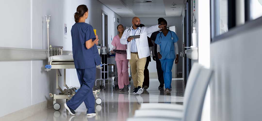 doctors discussing work and walking through corridor at hospital