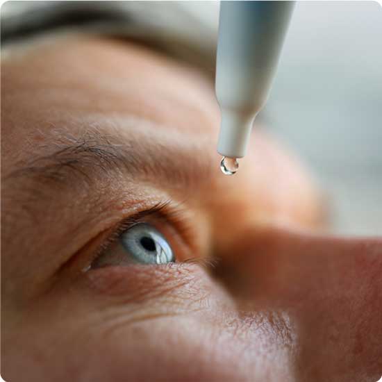 Eye wash drop in mans eye