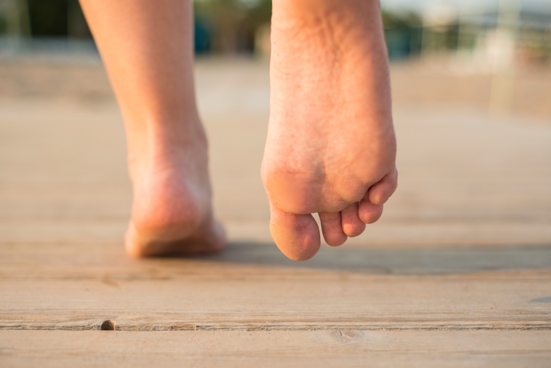 Feet walking on a wooden deck