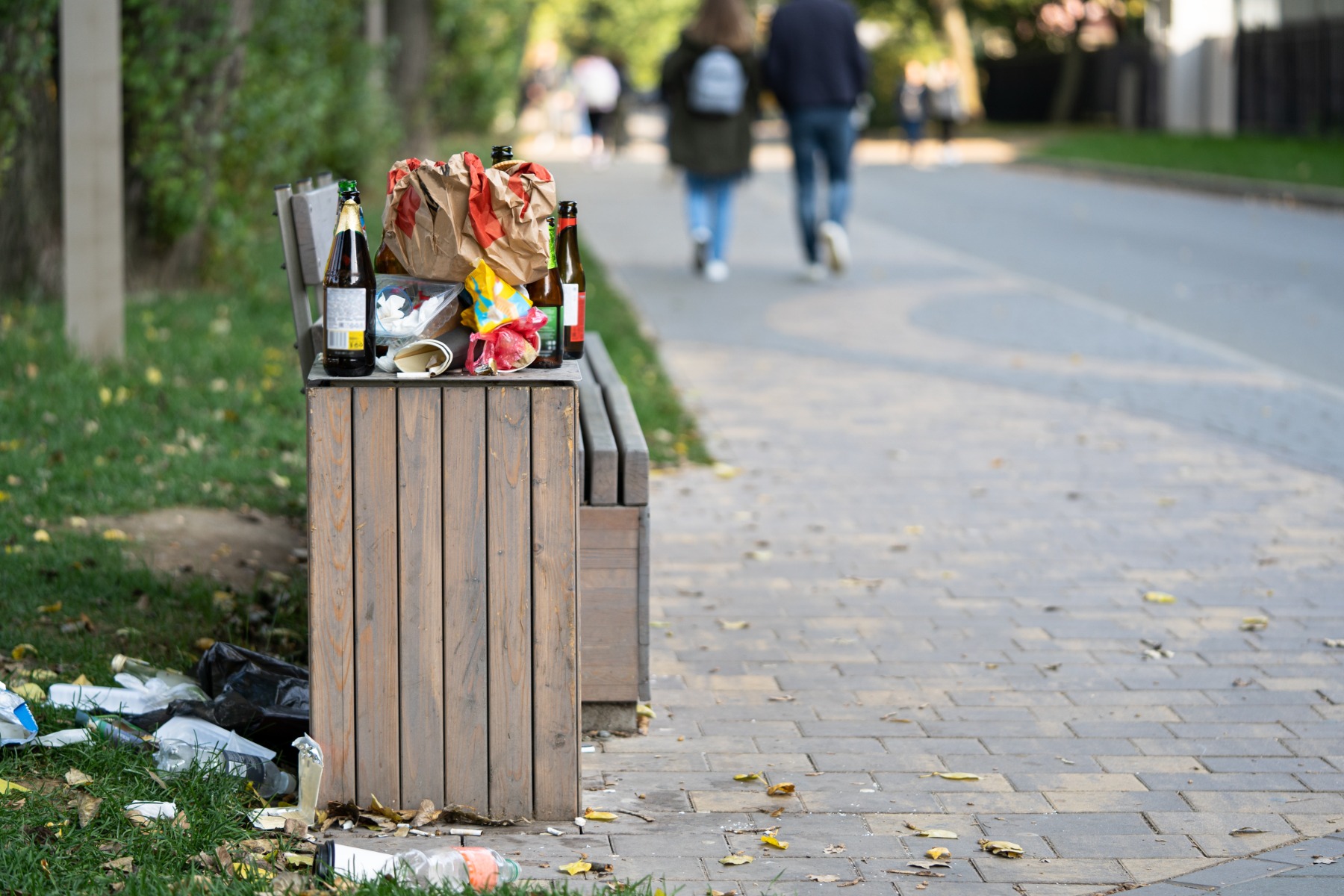 Overcrowded trash basket in the street.