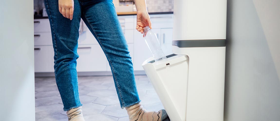 putting plastic bottle into Recycling Bin on The Kitchen. Waste sorting at home.
