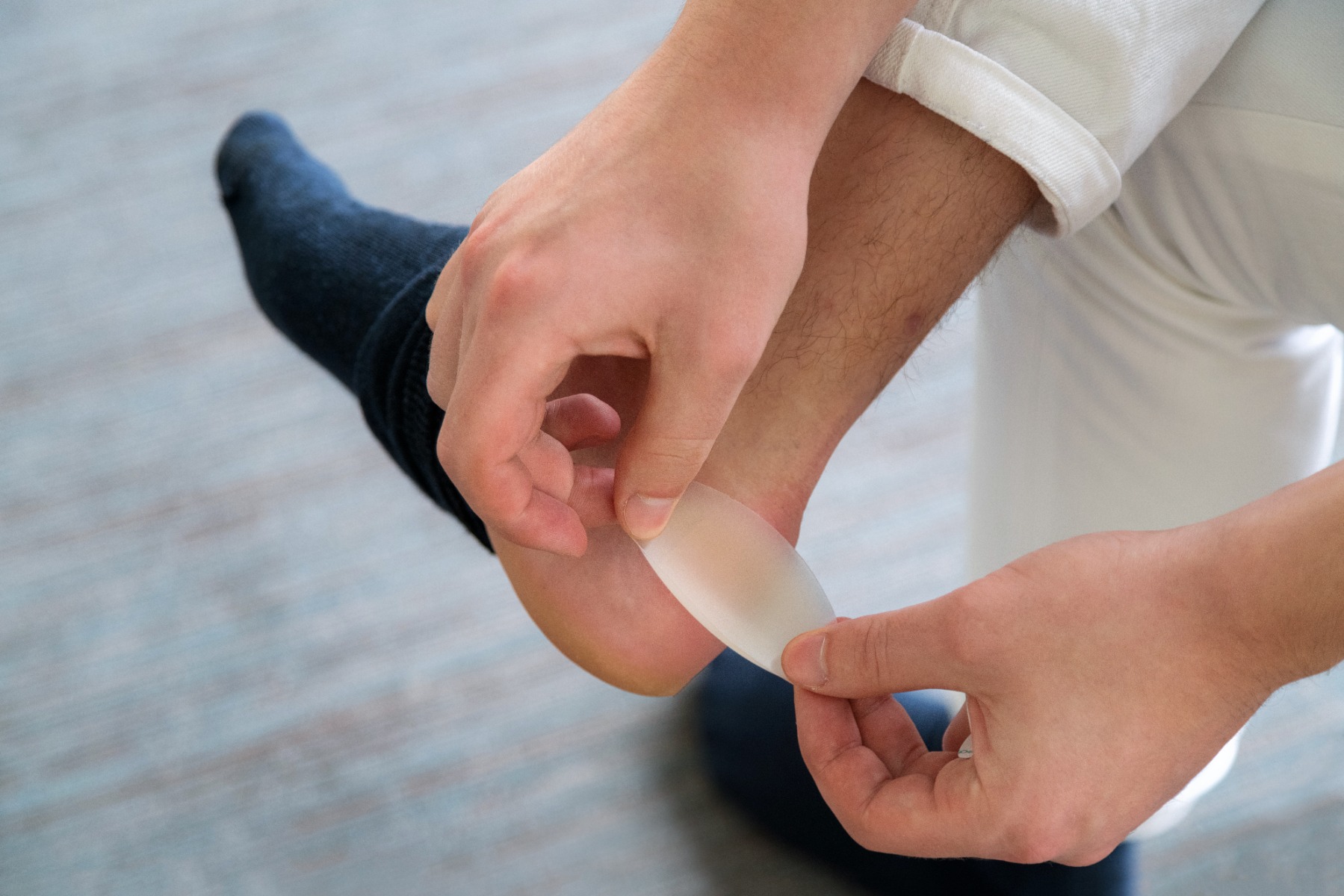 Man applying blister plaster on the back of ankle