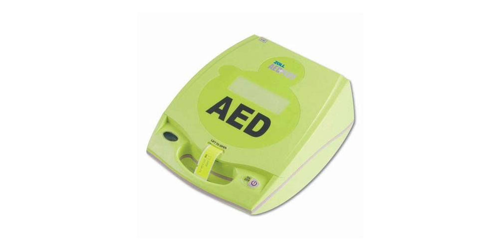 Green Zoll AED Plus defibrillator with 'AED' printed prominently on the front. The device is designed for providing automated external defibrillation in cardiac emergencies.