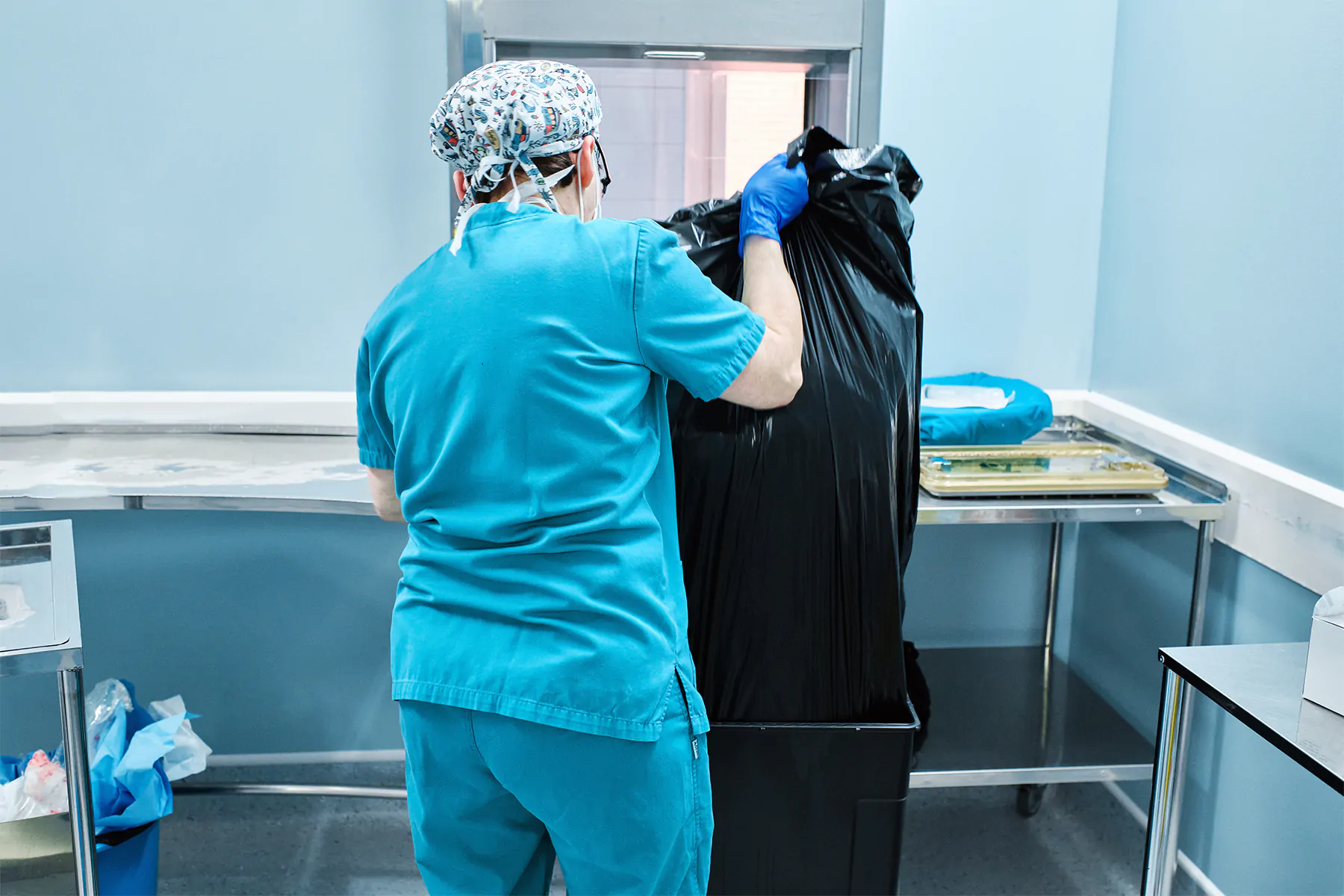 woman health workers remove a bag of garbage at a hospital woman health workers remove a bag of garbage at a hospital