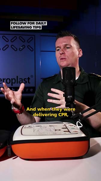 Trainer discussing CPR techniques and lifesaving advice, with AED unit on display.